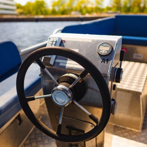 An interior shot of the Amstel boat that showcases the steering wheel and throttle