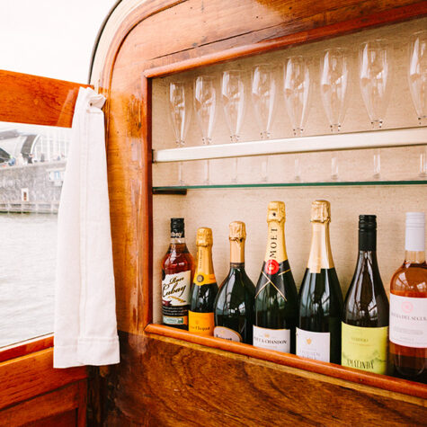 De bar aan boord van de Barbarella. Een rij champagnes en wijnen.