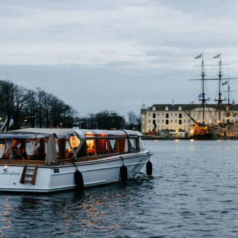 De salonboot voor 12 personen vaart langs het National Maritime Museum.