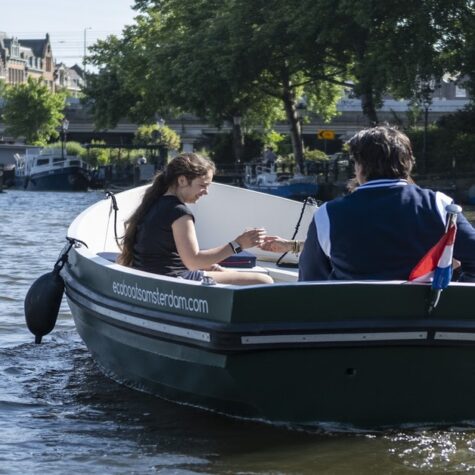 Een gezin dat een boot huurt om door de grachten van Amsterdam te varen