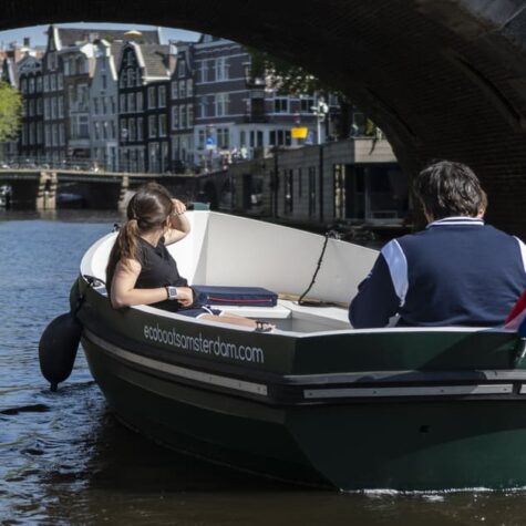 Een gezin dat met een zelfbestuurde boot de grachten van Amsterdam verkent