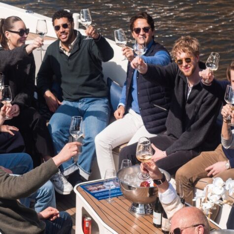 Een groep vrienden drinkt wijn aan boord van een Eco Boats-cruise