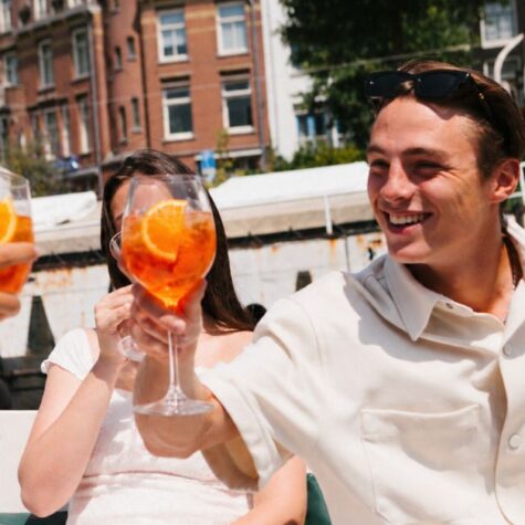 Vrienden genieten van een gezellig moment langs de grachten tijdens de Amsterdam Spritz Cruise