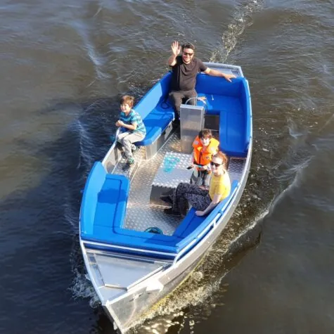 Een gezin dat een tochtje maakt met de Amstel Sloop op de grachten van Amsterdam