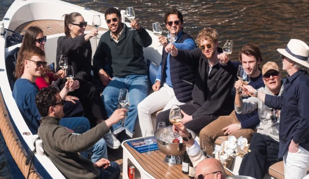 Een groep vrienden drinkt wijn aan boord van een Eco Boats-cruise
